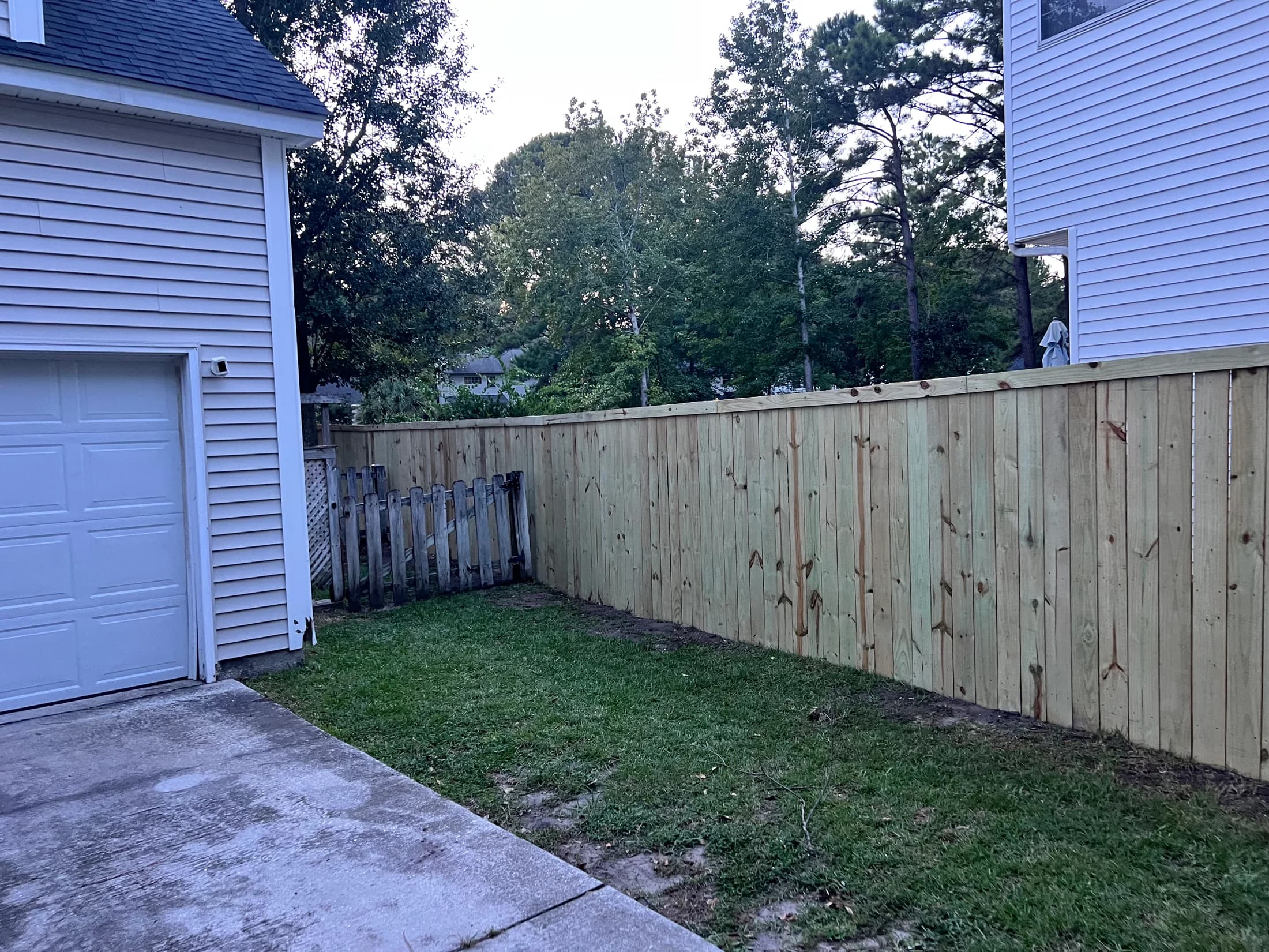 Long wood privacy fence between two homes, viewed from the driveway