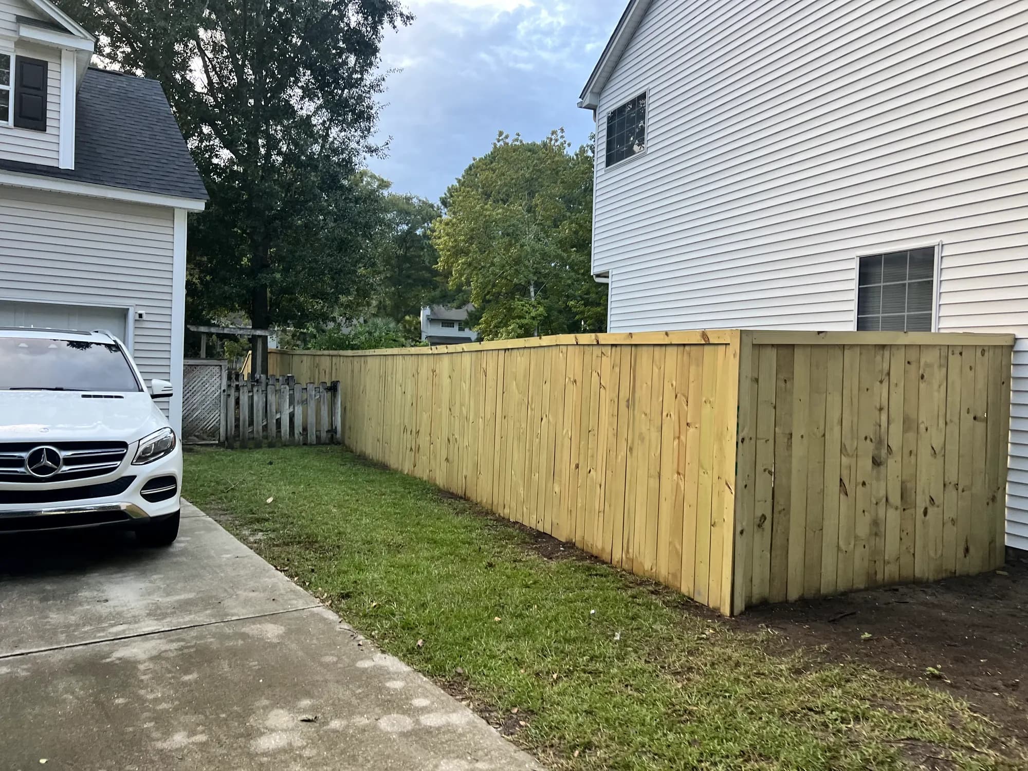 New capped wood privacy fence running between two homes