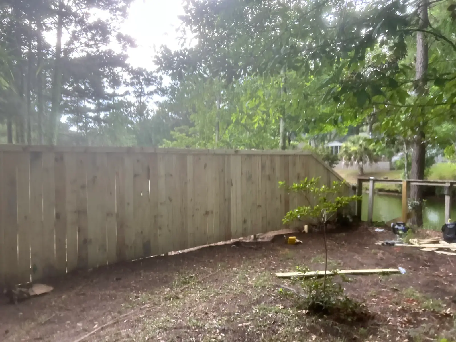 Finished privacy fence along a wooded yard
